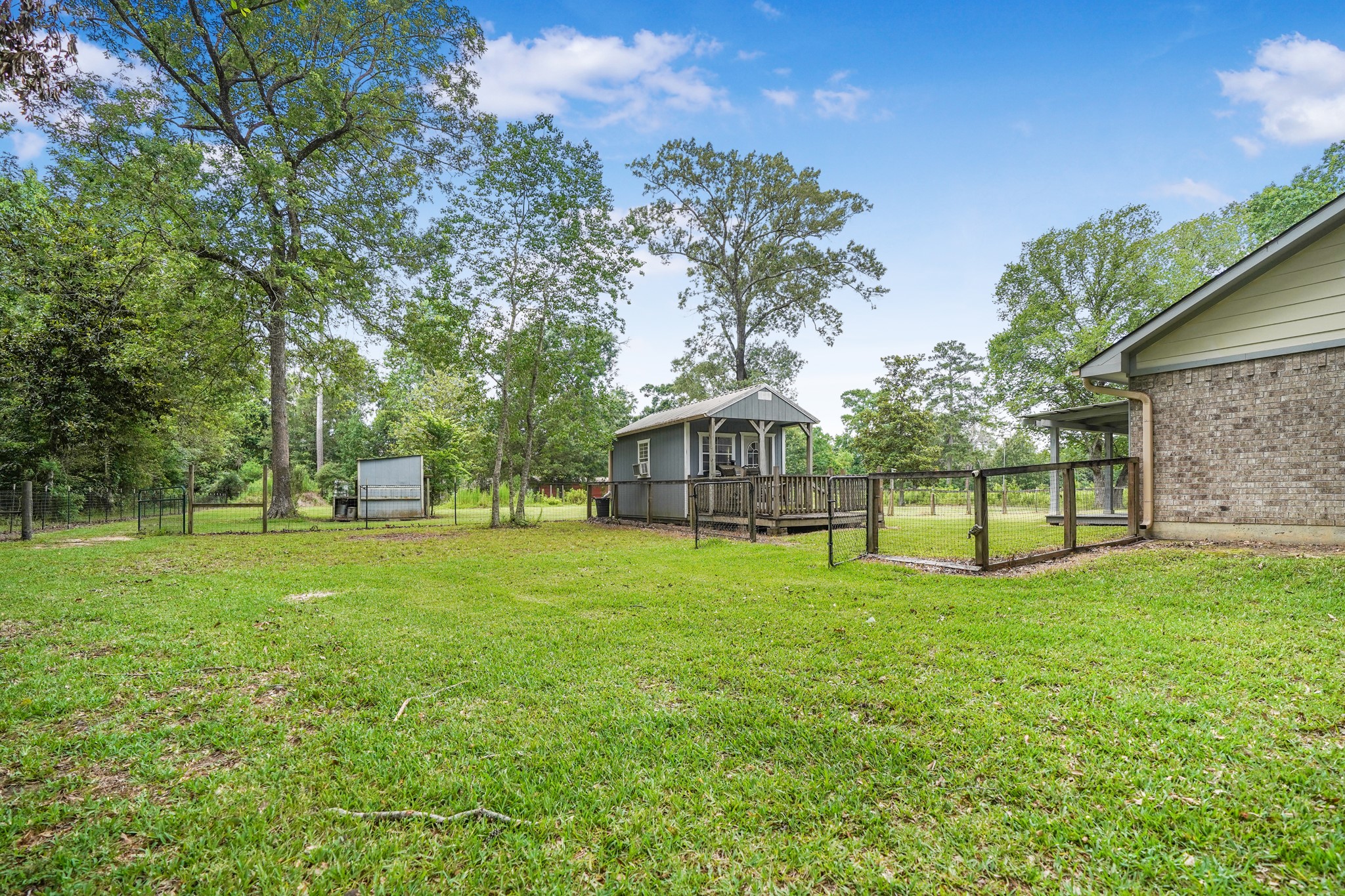 1003 Cherry Creek Road Dayton, TX 77535 - Photo 5 of 45 This view shows the side of the house with a she-shed and a chicken coop!