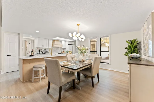a view of a dining room with furniture and a chandelier