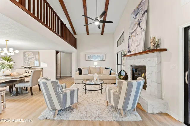a living room with furniture a fireplace and a chandelier