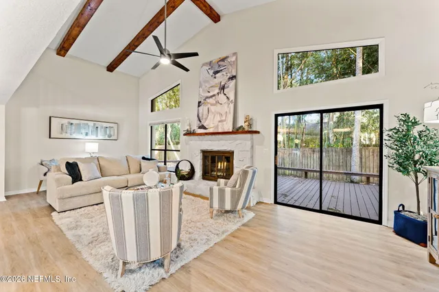 a living room with furniture a fireplace and a flat screen tv