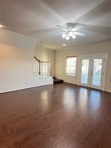 a view of an empty room with window and wooden floor