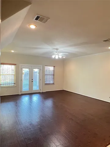an empty room with wooden floor and windows