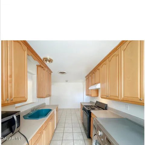 a kitchen with a sink a stove and cabinets