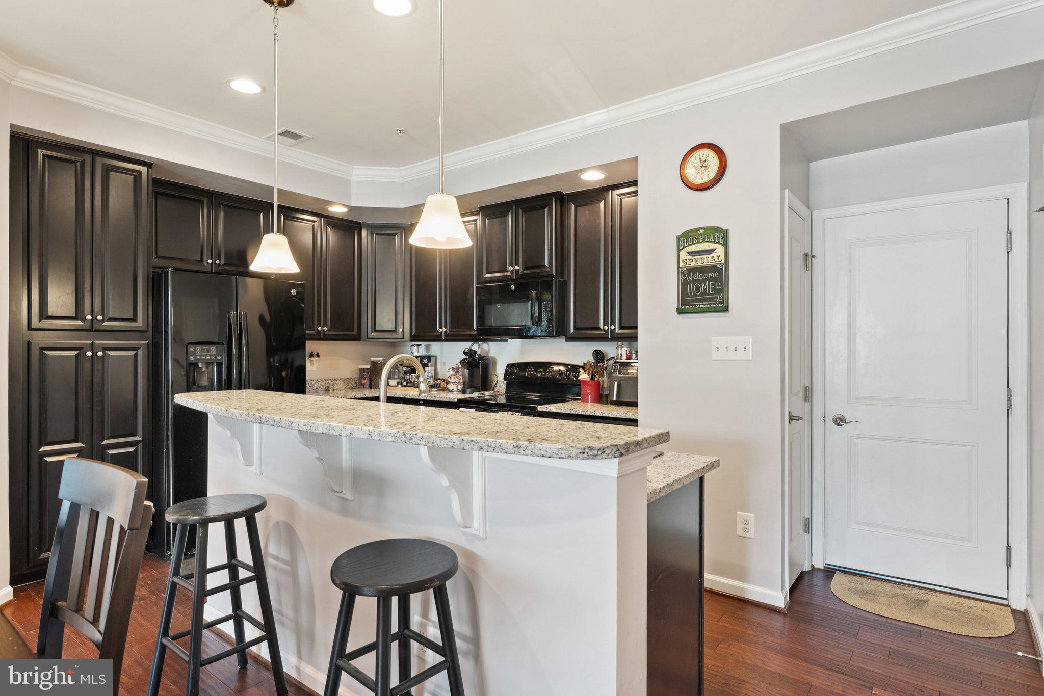 7494 Brunson Circle Gainesville, VA 20155 - Photo 11 of 49 a kitchen with stainless steel appliances granite countertop a refrigerator a stove and a sink with wooden floor