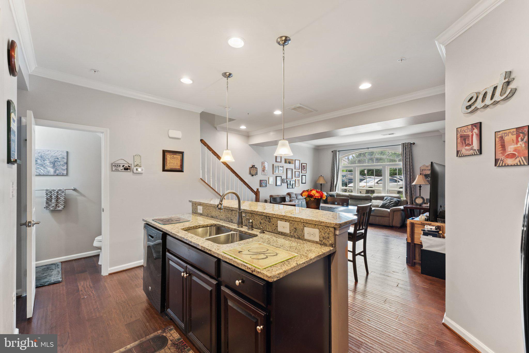 7494 Brunson Circle Gainesville, VA 20155 - Photo 15 of 49 a view of a kitchen with kitchen island a stove a refrigerator a dining table and chairs with wooden floor
