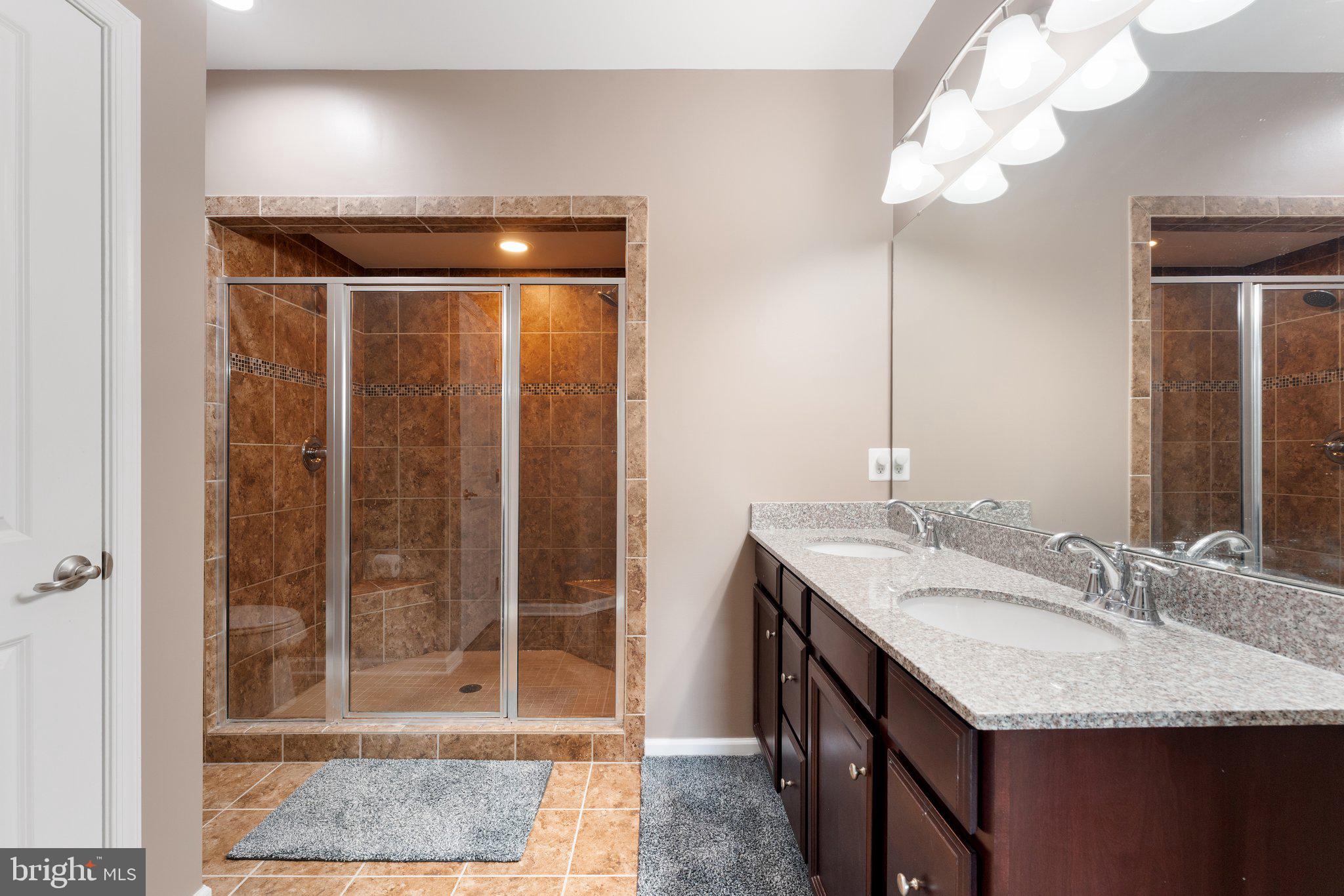 7494 Brunson Circle Gainesville, VA 20155 - Photo 42 of 49 a bathroom with a granite countertop sink a mirror and vanity