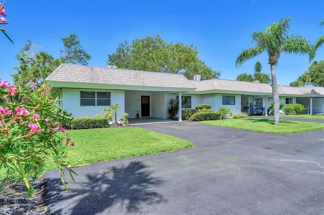 a front view of a house with a yard and potted plants