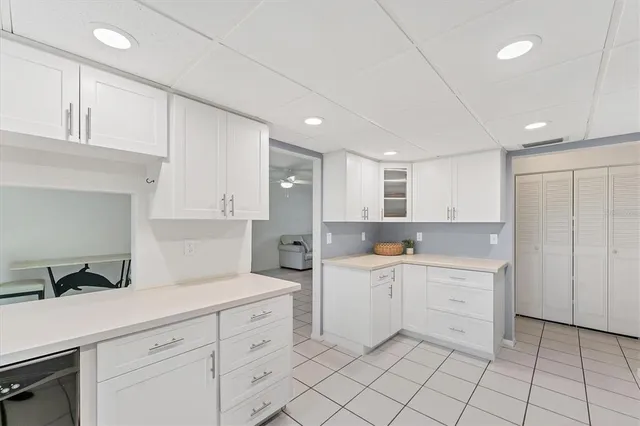 a kitchen with white cabinets and sink
