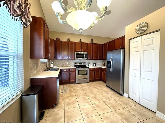 a kitchen with stainless steel appliances granite countertop a refrigerator a sink a stove and island