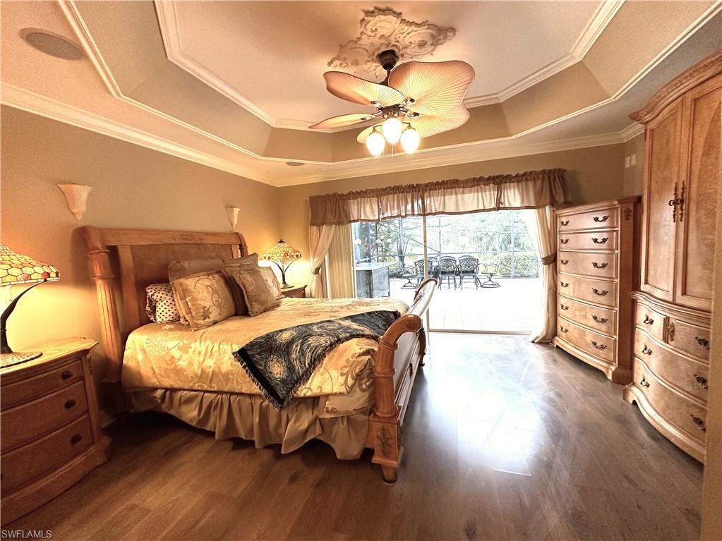 1357 Triandra Lane Naples, FL 34119 - Photo 13 of 40 a spacious bedroom with a bed and wooden floor