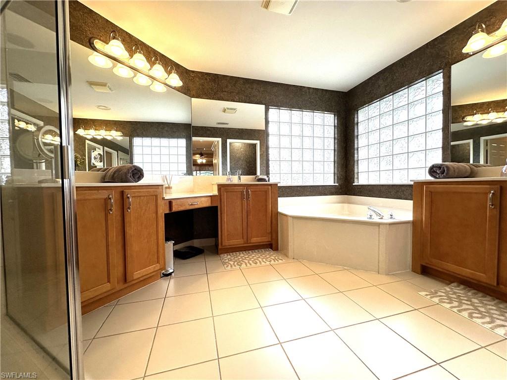 1357 Triandra Lane Naples, FL 34119 - Photo 15 of 40 a kitchen with stainless steel appliances kitchen island granite countertop a refrigerator and a stove top oven