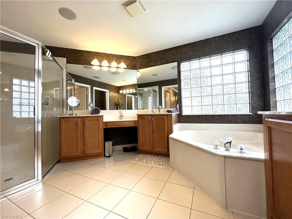 1357 Triandra Lane Naples, FL 34119 - Photo 16 of 40 a large spacious bathroom with a tub a sink and mirror
