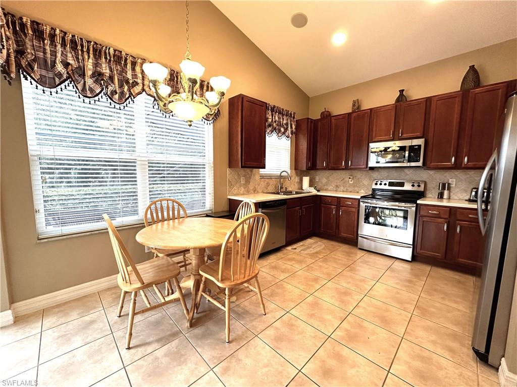 1357 Triandra Lane Naples, FL 34119 - Photo 10 of 40 a kitchen with stainless steel appliances kitchen island granite countertop a sink and cabinets