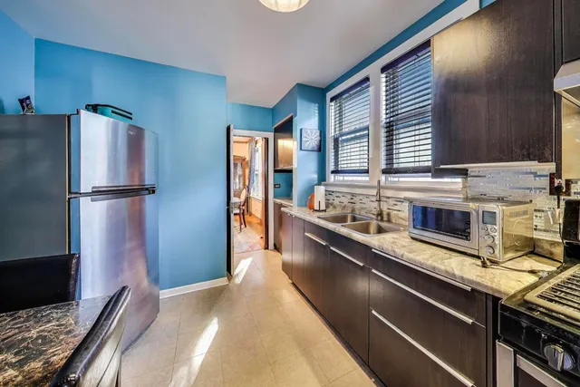 a kitchen with stainless steel appliances granite countertop a refrigerator a sink and a stove