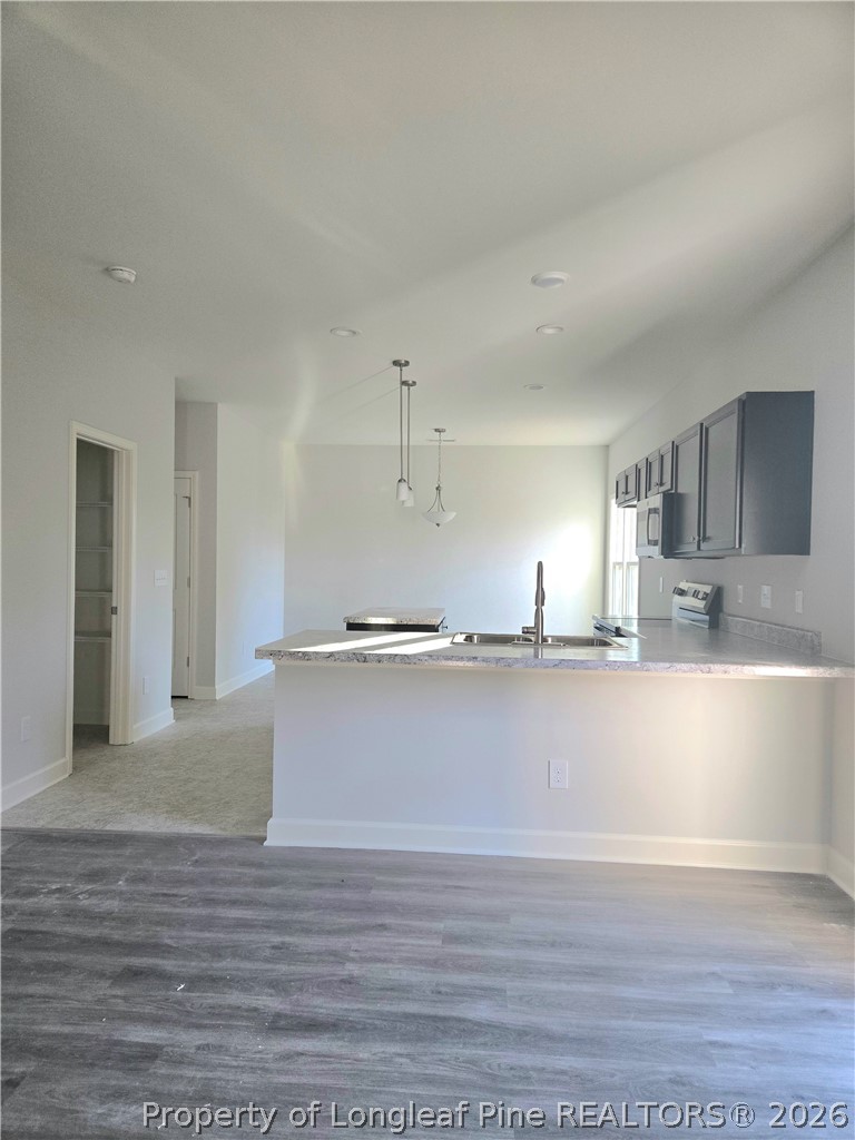 1354 East Manchester Road Spring Lake, NC 28390 - Photo 6 of 15 a view of a kitchen with kitchen island a sink wooden floor and a refrigerator