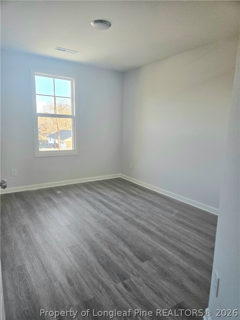 1354 East Manchester Road Spring Lake, NC 28390 - Photo 8 of 15 an empty room with wooden floor and windows