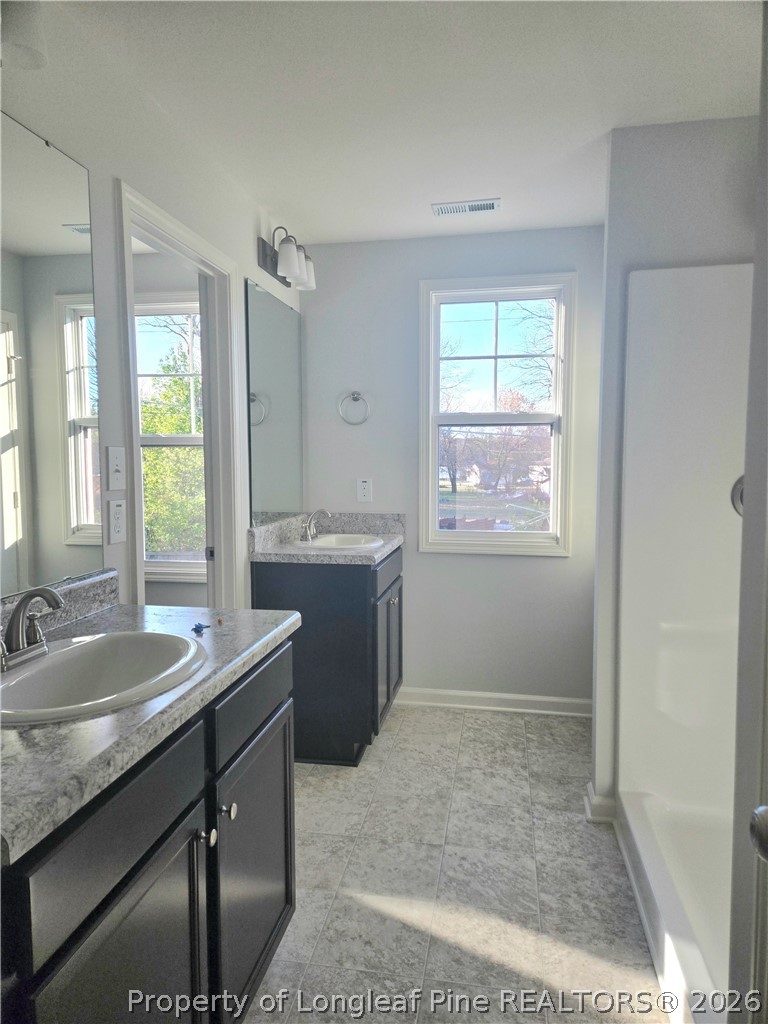 1354 East Manchester Road Spring Lake, NC 28390 - Photo 9 of 15 a bathroom with a granite countertop sink a mirror and a window
