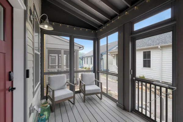 a view of a balcony with chairs and a barbeque
