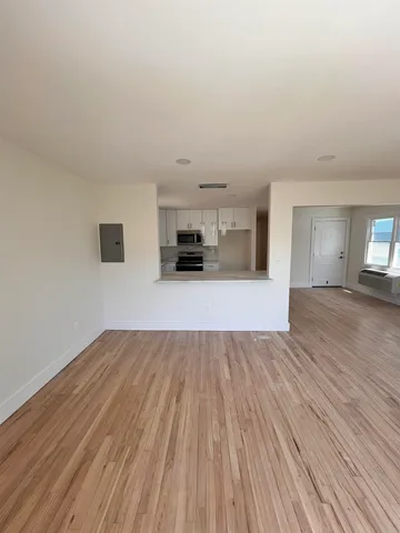 a view of a kitchen with wooden floor and a sink