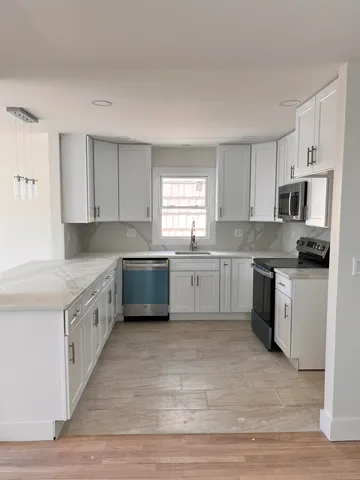 a kitchen with granite countertop white cabinets and white appliances