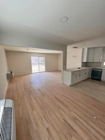 a big room with wooden floor and cabinets