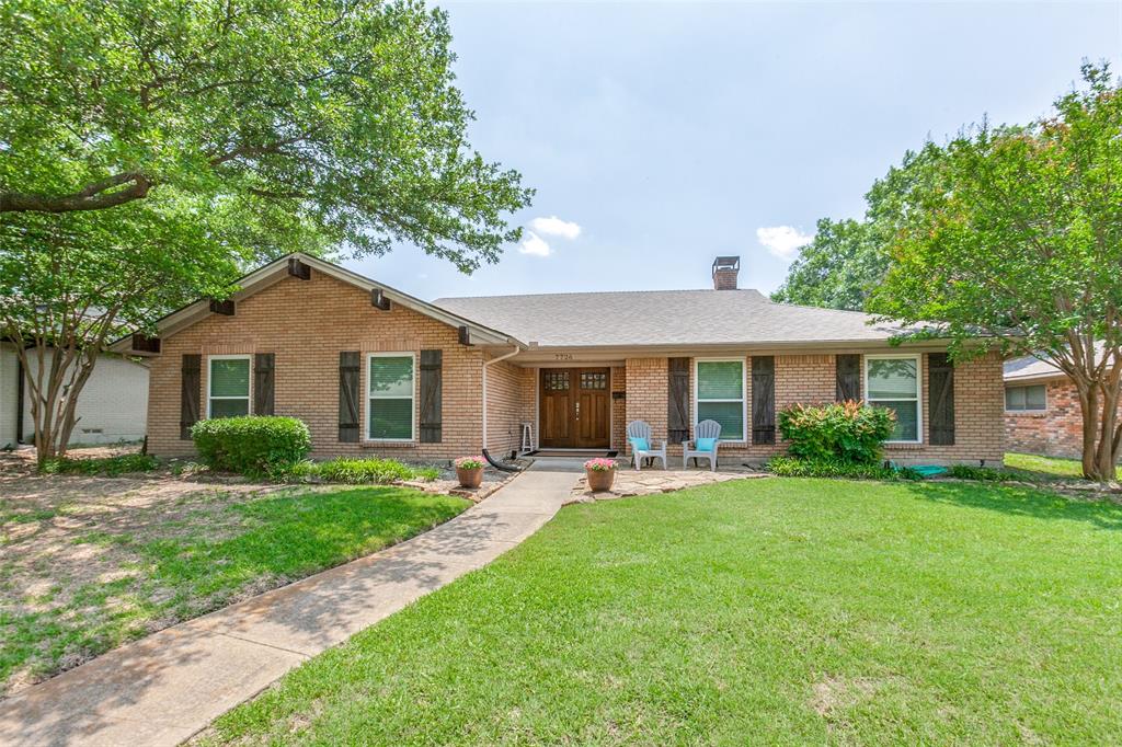 a front view of a house with a yard and trees