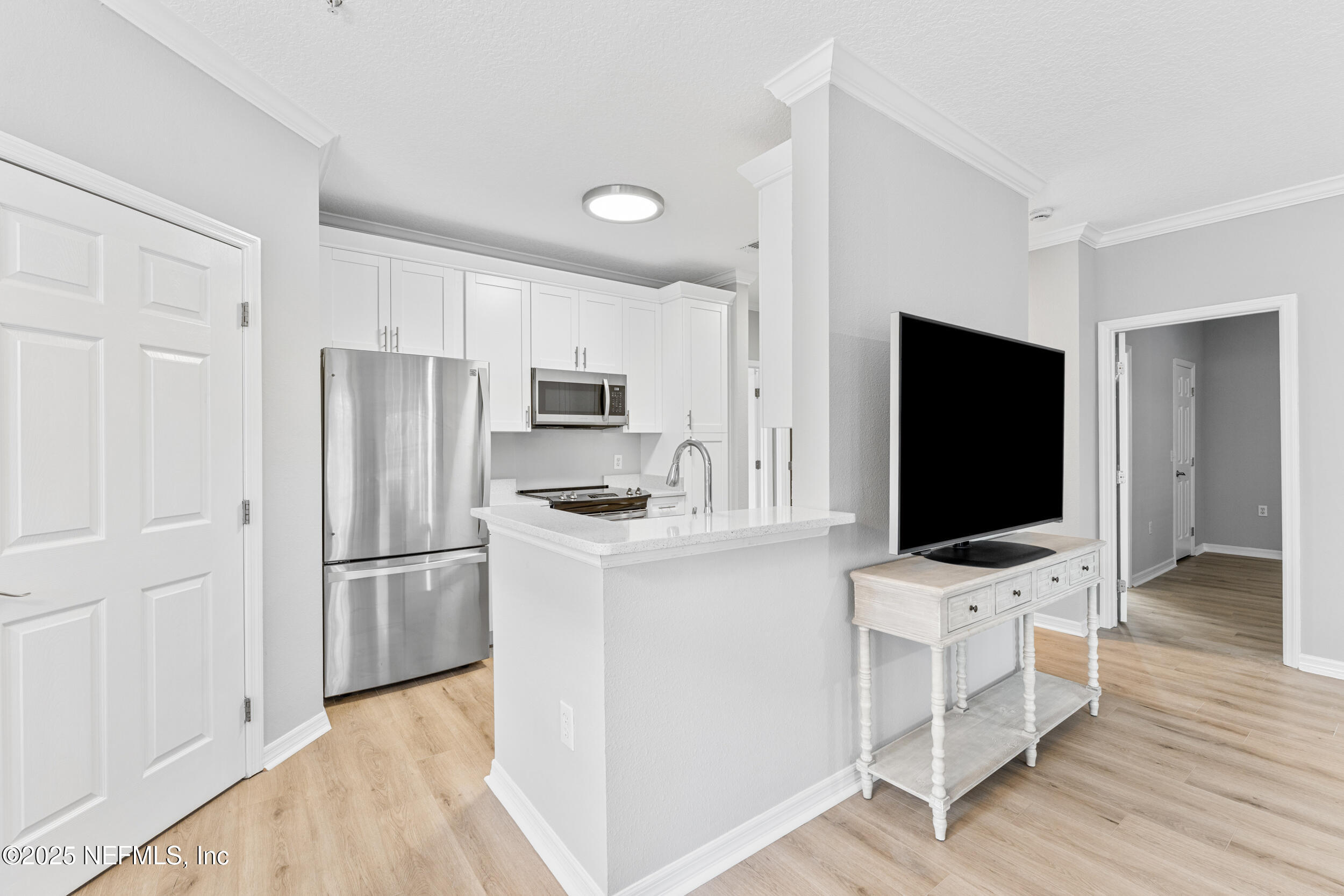 10961 Burnt Mill Road, Unit 621 Jacksonville, FL 32256 - Photo 8 of 19 a kitchen with white cabinets and stainless steel appliances