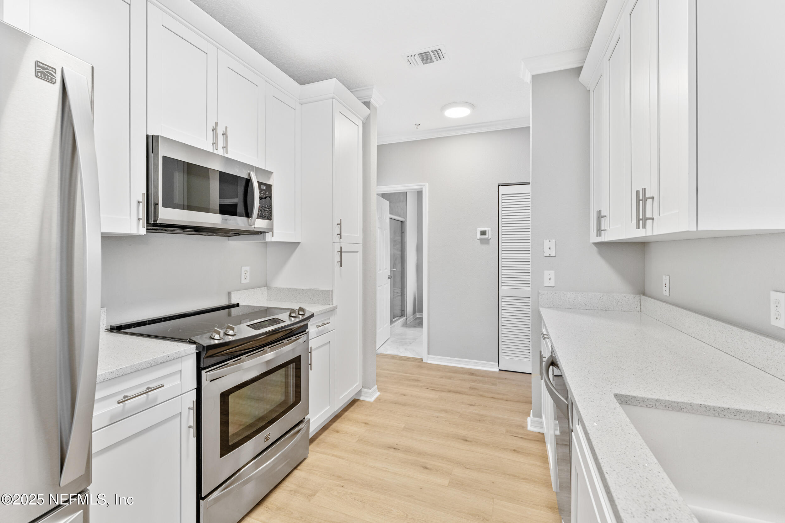 10961 Burnt Mill Road, Unit 621 Jacksonville, FL 32256 - Photo 9 of 19 a kitchen with stainless steel appliances white cabinets and a stove