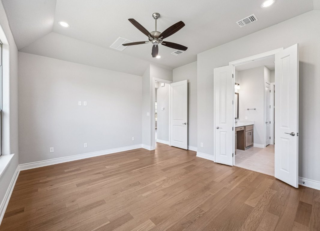 205 Indigo Lane Georgetown, TX 78628 - Photo 11 of 33 wooden floor in an empty room with a ceiling fan
