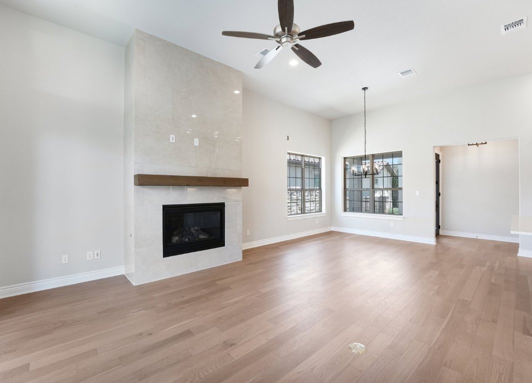 205 Indigo Lane Georgetown, TX 78628 - Photo 5 of 33 a view of an empty room with wooden floor fireplace and a window