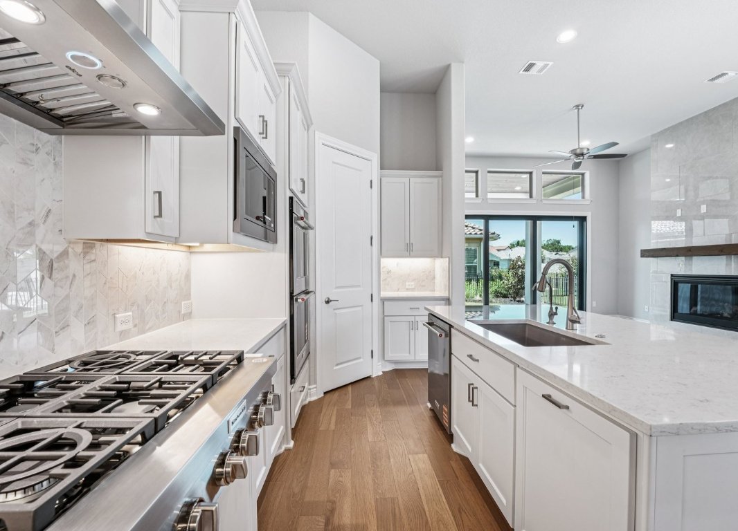 205 Indigo Lane Georgetown, TX 78628 - Photo 8 of 33 a kitchen with a stove a sink and a refrigerator