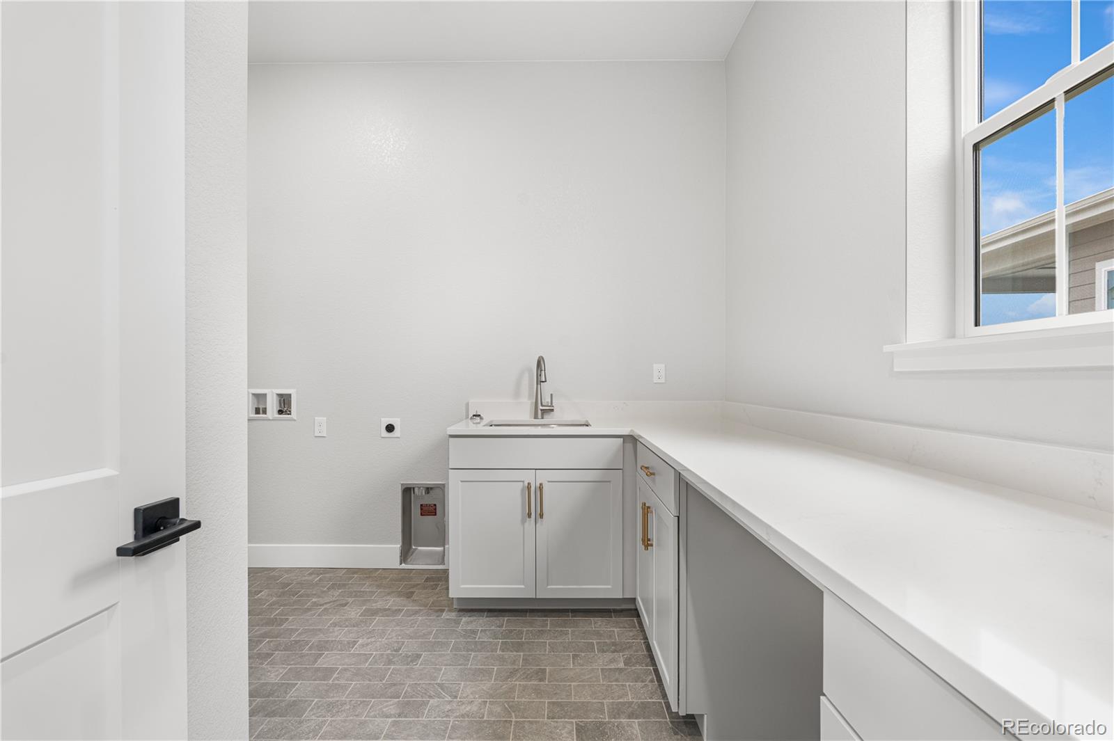7317 Timberstone Street Castle Pines, CO 80108 - Photo 30 of 49 a view of a kitchen with white cabinets and a sink