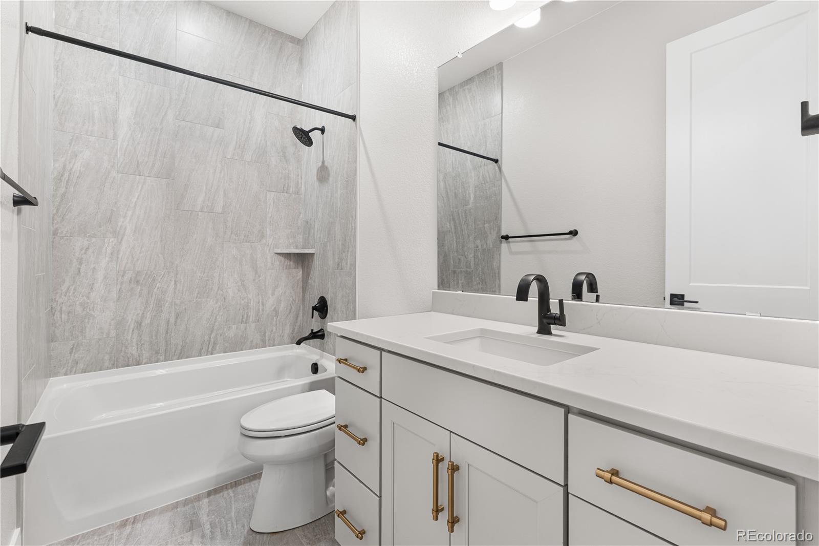 7317 Timberstone Street Castle Pines, CO 80108 - Photo 42 of 49 a bathroom with a granite countertop sink a toilet and a bathtub