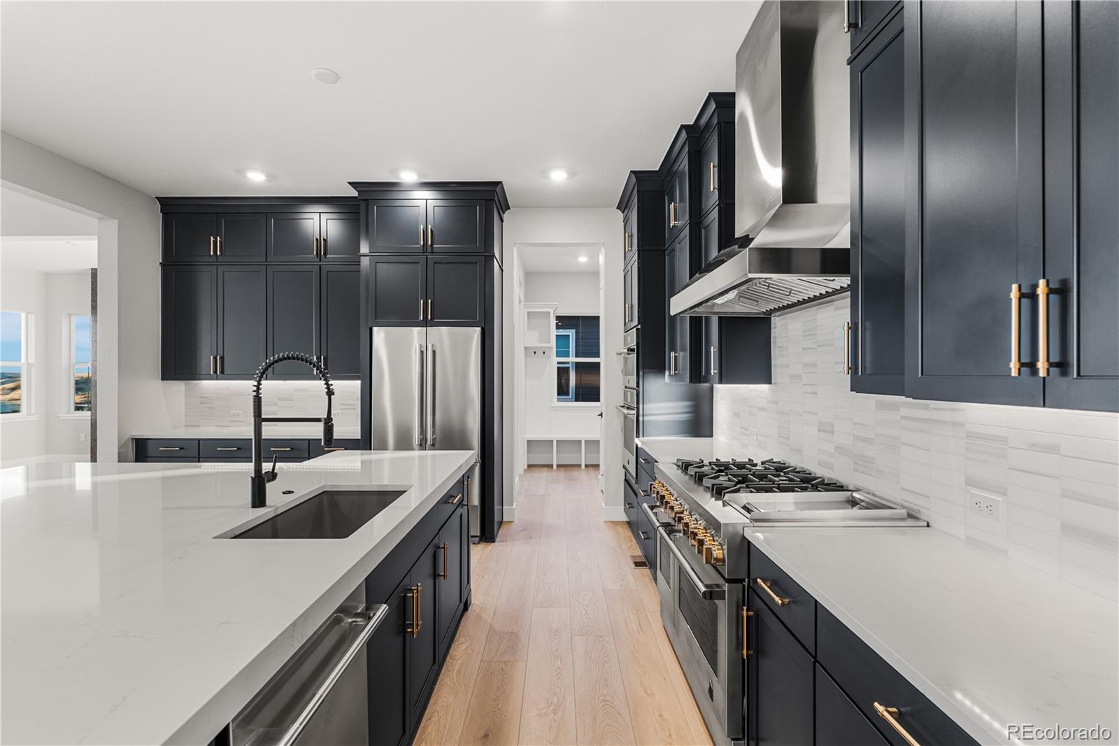 7317 Timberstone Street Castle Pines, CO 80108 - Photo 6 of 49 a kitchen with stainless steel appliances granite countertop a sink stove and refrigerator
