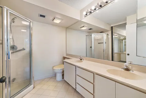 a bathroom with a double vanity sink mirror and toilet