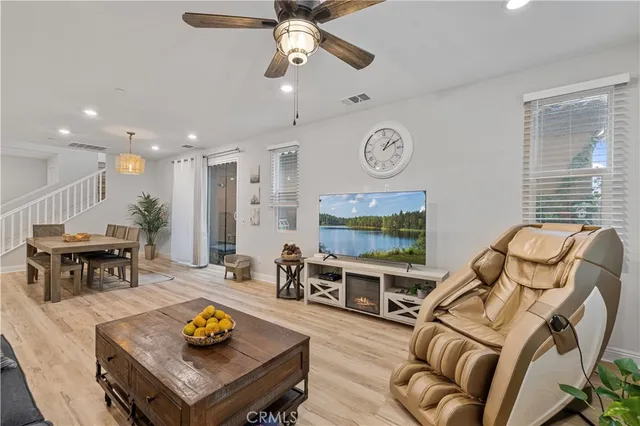 a living room with furniture kitchen view and a large window