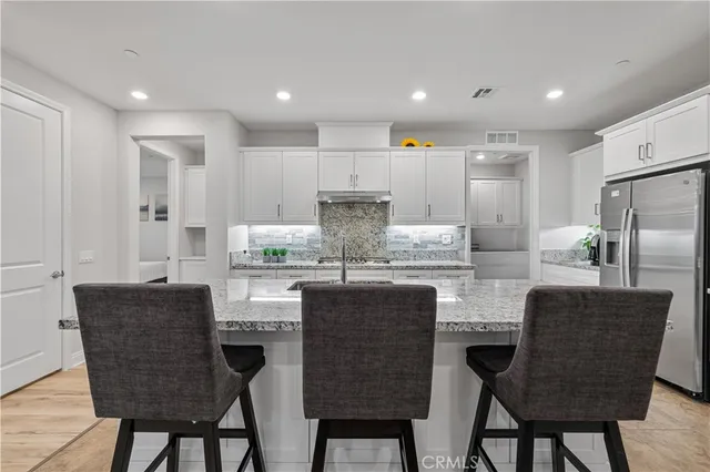 a kitchen with kitchen island granite countertop wooden cabinets and stainless steel appliances