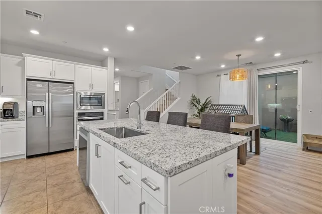 a kitchen with stainless steel appliances granite countertop a sink and a refrigerator