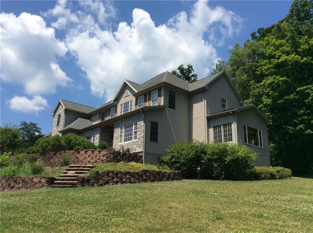 a front view of a house with a garden and plants