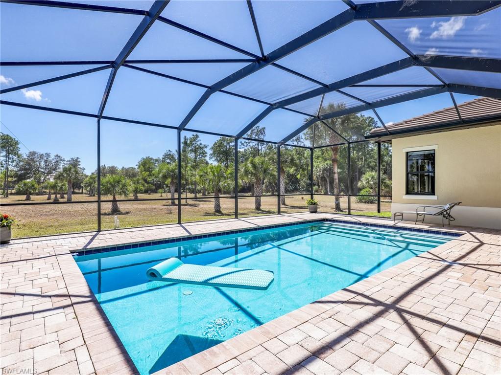 3160 27th Avenue Southwest Naples, FL 34117 - Photo 36 of 43 a view of a patio with a table and chairs under an umbrella