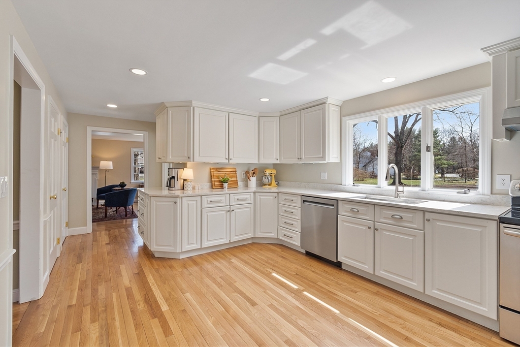 551 Barretts Mill Road Concord, MA 01742 - Photo 8 of 36 a kitchen with wooden floors and white cabinets