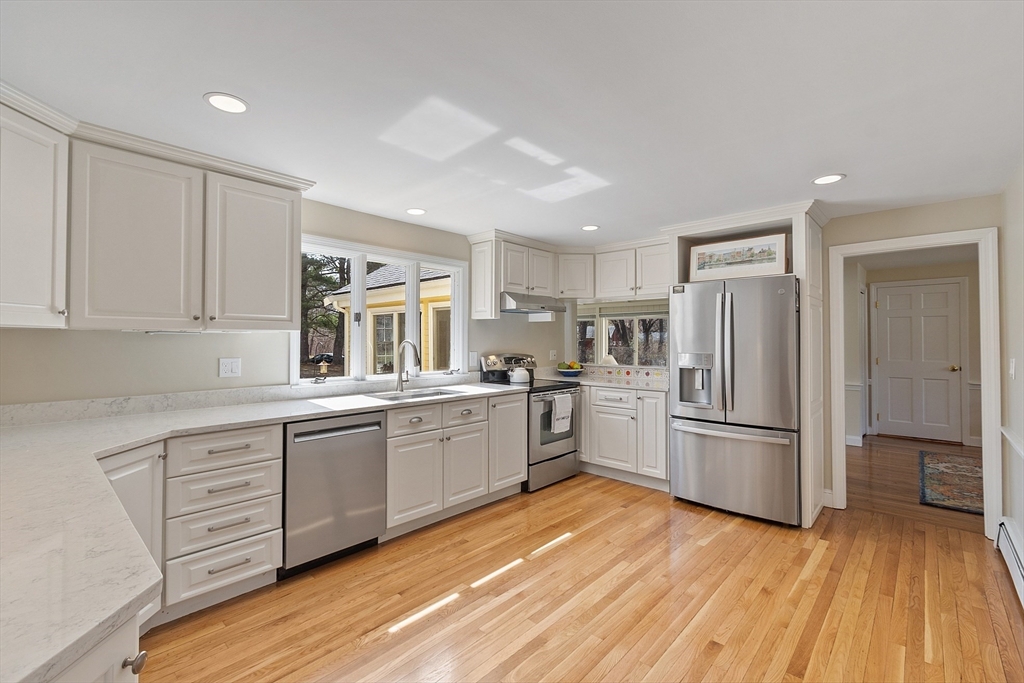 551 Barretts Mill Road Concord, MA 01742 - Photo 9 of 36 a kitchen with granite countertop a refrigerator and wooden floors