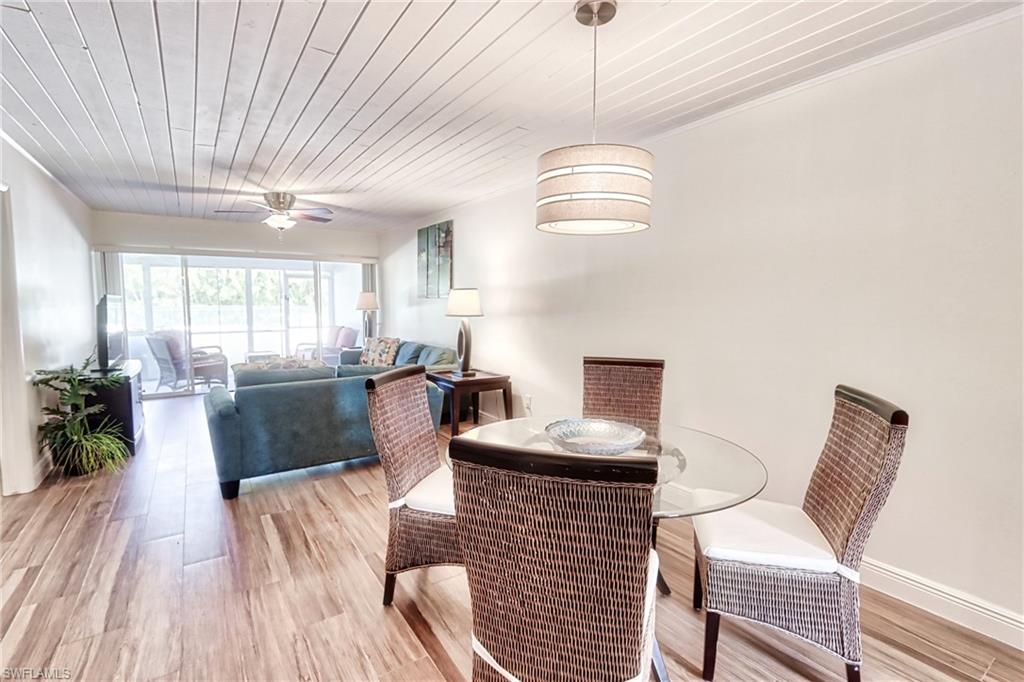 820 Ketch Drive, Unit 3 Naples, FL 34103 - Photo 7 of 19 a living room with furniture a chandelier and a dining table