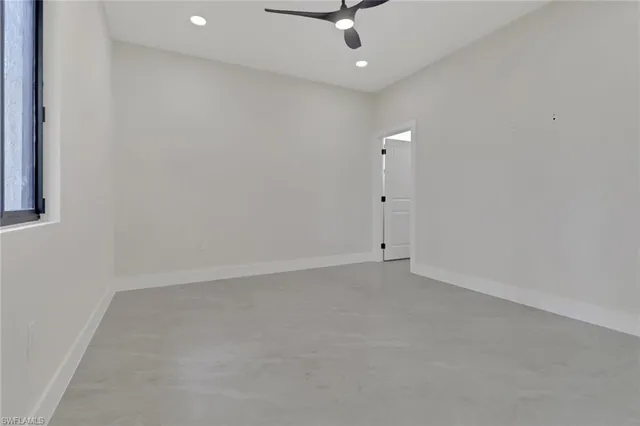 an empty room with a ceiling fan and window