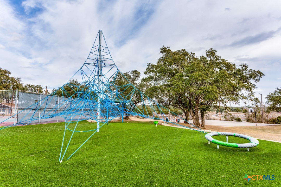 4 North Walnut Court Morgan's Point Resort, TX 76513 - Photo 6 of 9 a view of a backyard with a slide trees and wooden fence