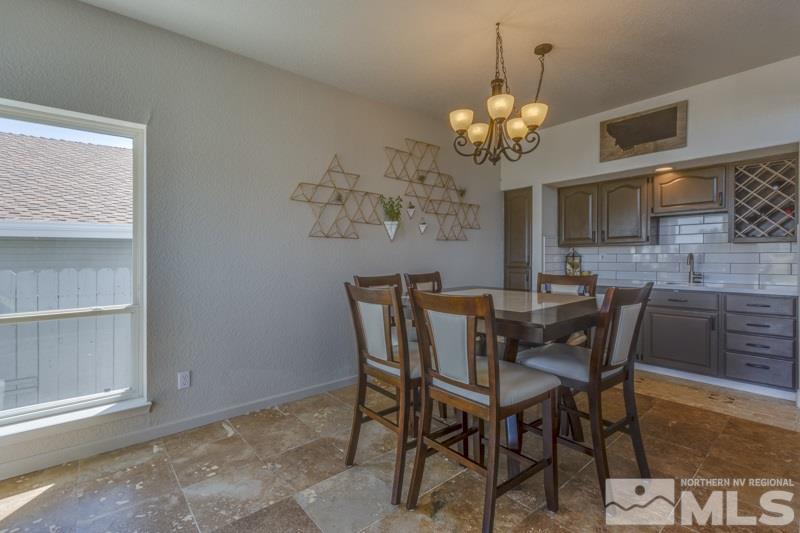 2245 Wide Horizon Drive Reno, NV 89509 - Photo 6 of 25 a dining room with wooden floor a chandelier a wooden table and chairs