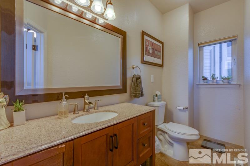 2245 Wide Horizon Drive Reno, NV 89509 - Photo 10 of 25 a bathroom with a granite countertop sink a toilet and a mirror