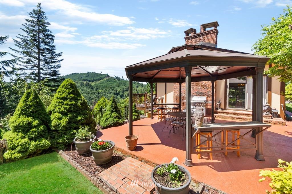1624 King Road Winlock, WA 98596 - Photo 8 of 39 a view of a patio with couches table and chairs under an umbrella with a small yard