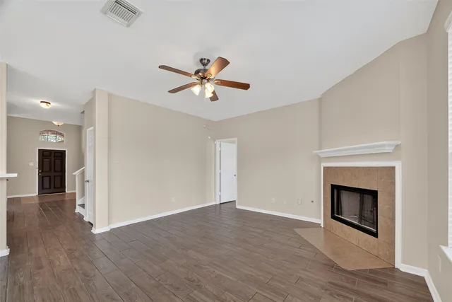 an empty room with wooden floor and a fireplace