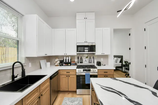 a kitchen with stainless steel appliances a sink a stove and cabinets